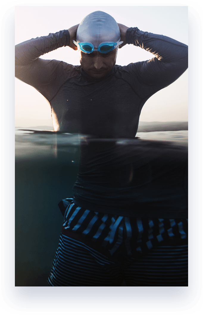 man standing waist deep in water before swimming